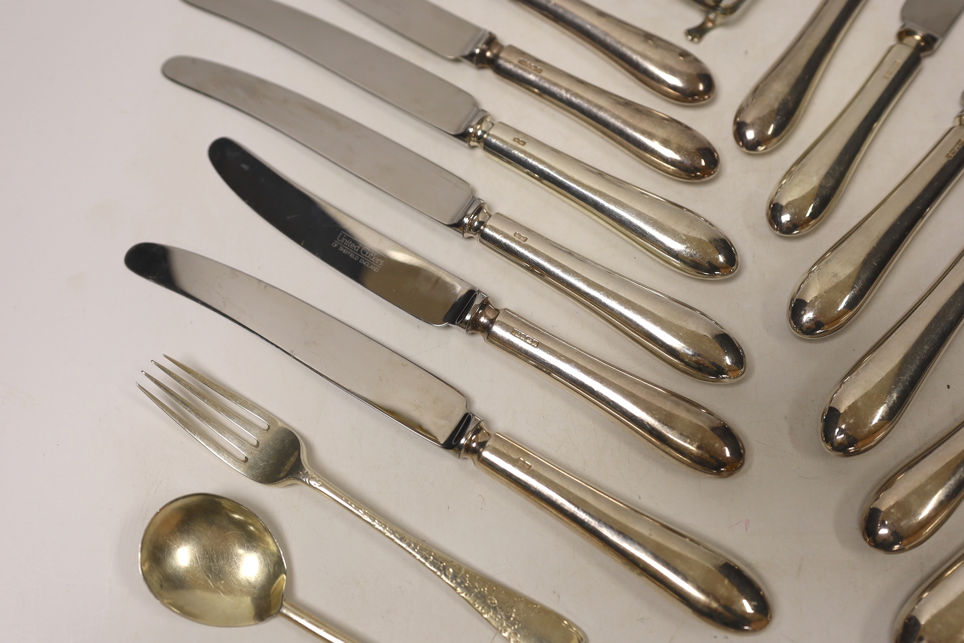 A set of six modern silver handled table knives and dessert knives, United Cutlers, Sheffield, 1997/8, a small silver five bar toast rack, two silver forks, a silver spoon and a pair of silver plated sugar tongs.
